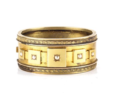 A late Victorian Etruscan Revival hinged bangle, unmarked yellow metal settings, set with split pearls, band width 28.3mm, in