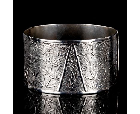 A large early 20th century silver Aesthetic Movement hinged bangle, engraved chinoiserie decoration, maker's marks NK, hallma