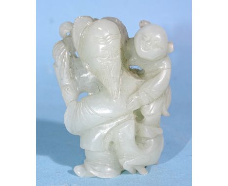 A Chinese carved jade figure of a man carrying a child, with a goat at his feet, 5cm high. 