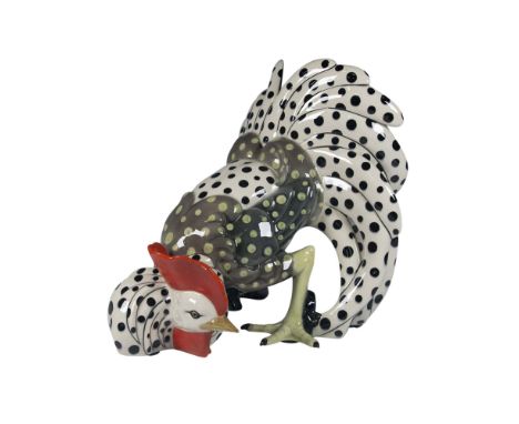 A large rooster figure decorated with black polka dots on a white background, and yellow-green polka dots on a gray backgroun