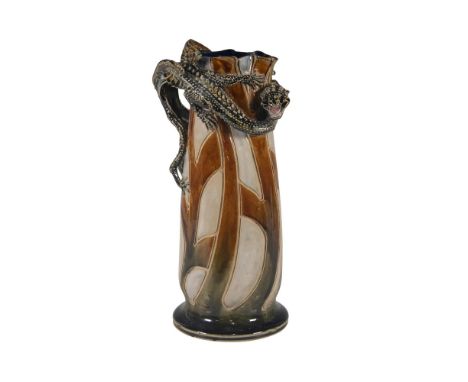 In tones of brown, green, and light gray the body of the pitcher is decorated in an abstract foliate-like pattern with deep i