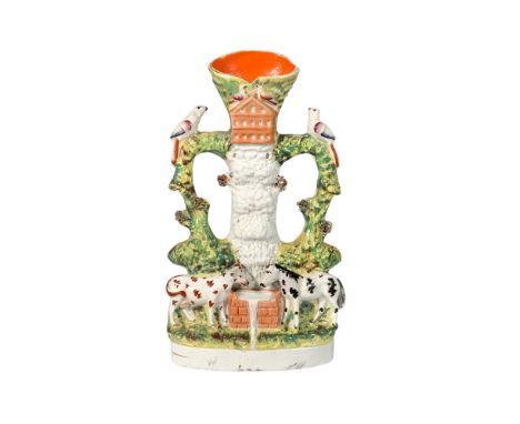 Ceramic figure adorned with vibrant colors, depicting a rural scene of a cow and horse drinking water from a trough, with bir