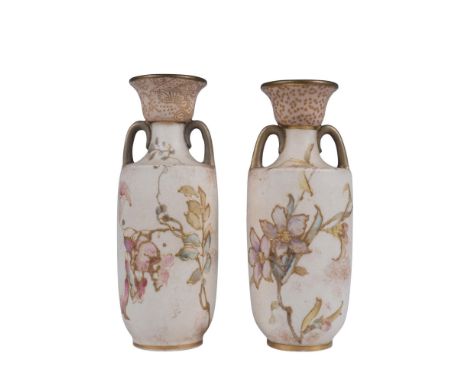 A pair of matte light pink vases that feature blooming pink flowers and are adorned with gilded accents. Royal Doulton backst