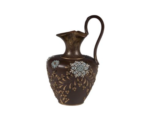 A brown pitcher is decorated with blue, white, and gold floral arrangements, creating an elegant design. Doulton Lambeth back