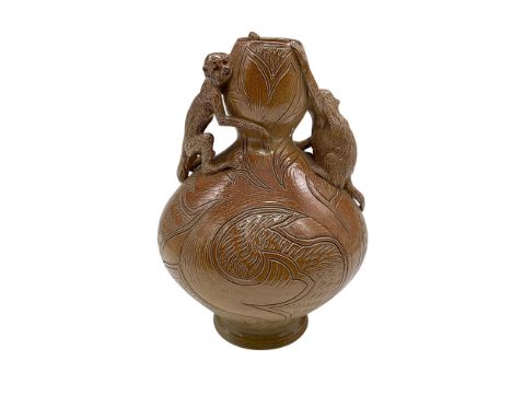 A gourd-shaped salt glazed vase decorated with incised stylized leaves, and two sculpted monkeys as the double handles. Doult