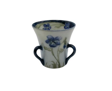 A small three-handled flared vase. The exterior is decorated in the blue Violet pattern, and the interior rim is features a g
