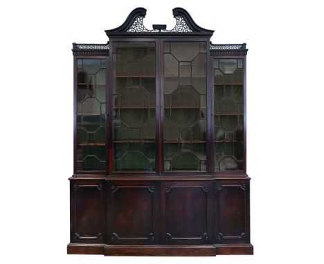 A GEORGE III MAHOGANY LIBRARY BREAKFRONT BOOKCASE, CIRCA 1780. with Chippendale style fret cut scroll pediment to astragal gl