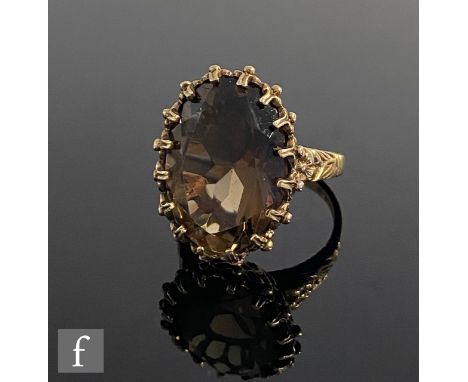 A 9ct hallmarked single stone smoky quartz ring, claw set stone to flower head detailed shoulders, weight 5.5g, ring size K. 