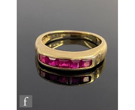 A 14ct ruby ring comprising five square cut channel set stones to plain shoulders, weight 3.9g, ring size P. 