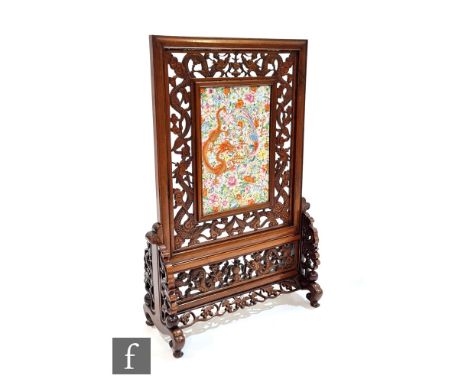 A 19th Century Chinese porcelain panel table screen decorated with a dragon and exotic bird within carved pieced hardwood fra