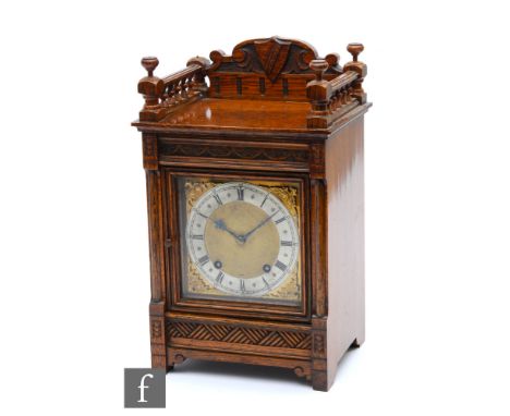 A late 19th Century oak mantle clock with eight day movement striking on a gong, stamped W&amp;E Soh, enclosed by a glazed do