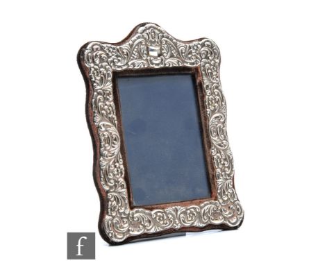 A hallmarked silver rectangular easel photograph frame with embossed foliate decoration to whole, height 20cm, Sheffield 1985