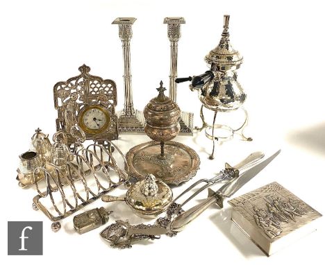 A parcel lot of assorted silver plated items to include a pair of candlesticks, a toast rack, an easel clock, a carving knife
