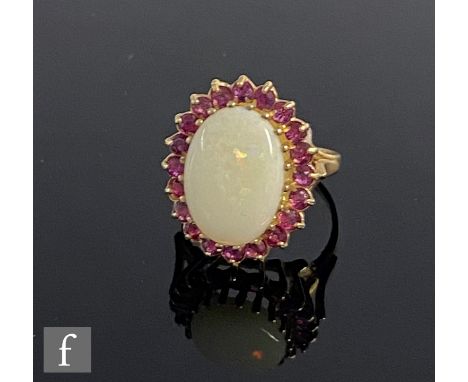 A 9ct hallmarked opal and ruby cluster ring, central oval opal within a border of rubies, weight 3.6g, ring size J. 