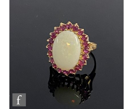 A 9ct hallmarked opal and ruby cluster ring, central oval opal within a border of rubies, weight 3.6g, ring size J. 