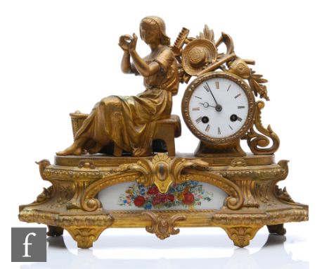 A 19th Century French gilt mantle clock, with a girl seated near a basket of fruit, enamelled dial and eight day striking mov