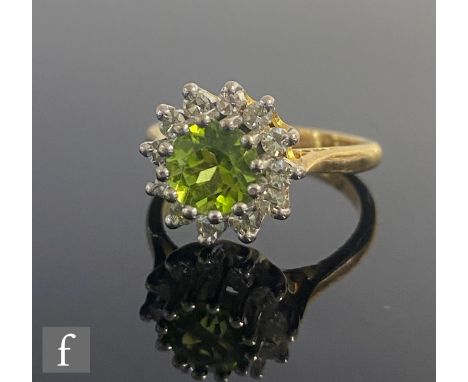 An 18ct hallmarked peridot and diamond cluster ring, central peridot within a border of twelve brilliant cut diamonds, weight