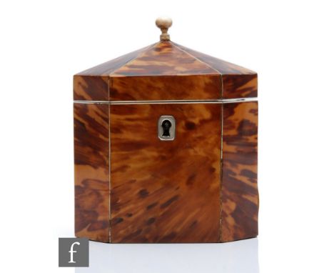 An early 19th Century tortoiseshell and ivory line inlaid tea caddy of octagonal form, the hinged pagoda shaped top with turn