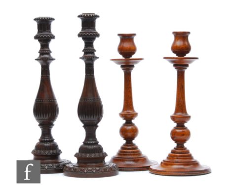 A pair of 19th Century carved hardwood baluster candlesticks on turned Greek Key bases, height 36cm, and a pair of similar li