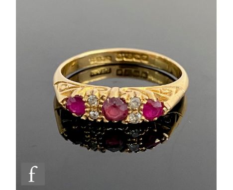 An 18ct hallmarked Edwardian style ruby and diamond seven stone ring, three rubies spaced by pairs of diamonds, weight 3.5g, 