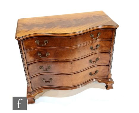 An early 20th Century mahogany serpentine fronted chest of four graduated cock-beaded drawers in the George II style, the oak