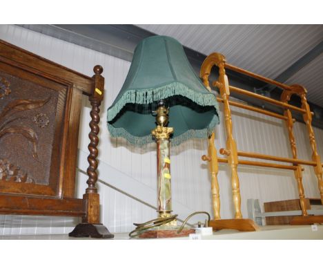 A decorative onyx and gilded table lamp with tasselled shade