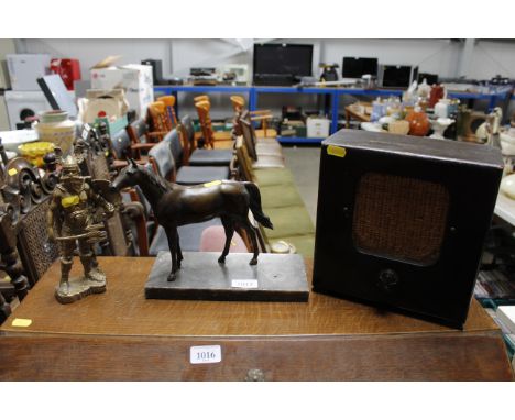 A bronzed model of a horse; a vintage radio speaker; and a brass model of a Viking 