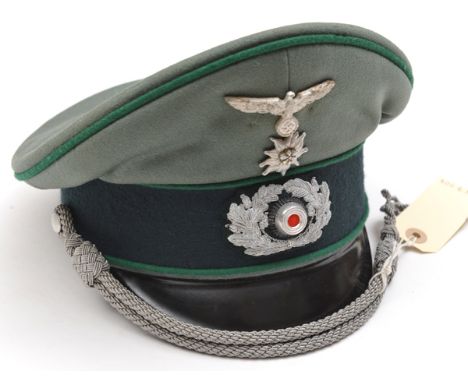 A Third Reich Mountain Troop army officer’s peaked cap, of light field grey cloth with black band, green piping, black fibre 