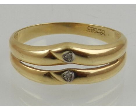 A 14 carat yellow gold double band ring, set with two round cut diamonds. 