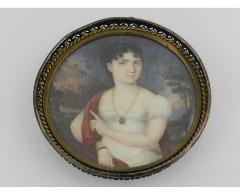 An early 19th century circular portrait miniature of a seated lady, oil on card, in a sterling silver frame. D: 8cm