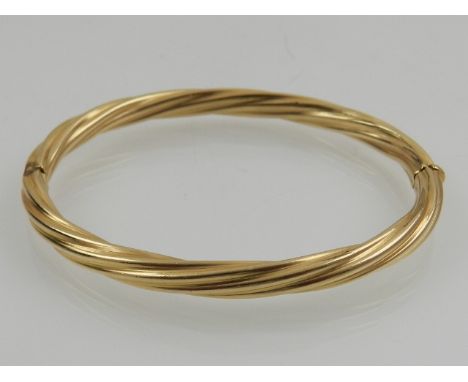 An 14 carat yellow gold writhen bangle. 