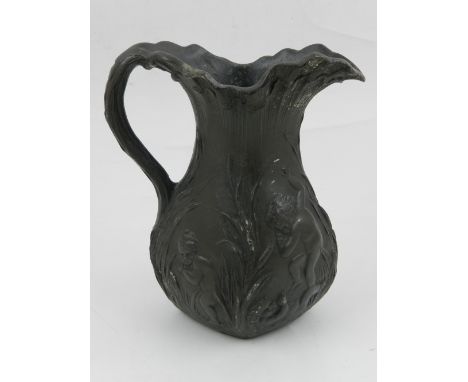 A late 19th / early 20th century pewter jug, decorated with children playing amongst reeds. 