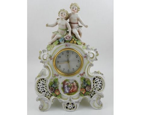 A 20th century Continental porcelain mantle clock, having mounted porcelain cherubs to top, decorated with flowers and centre