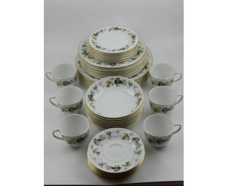 A Royal Doulton part dinner / tea service, pattern Larchmont, the border decorated with a continuous design of leaves, gilt e
