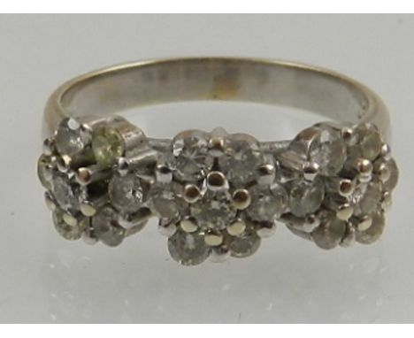 A white gold and diamond set triple floral cluster ring. 