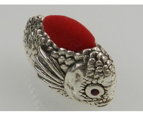 A novelty silver pincushion in the form of a fish, with ruby eyes. 