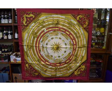 Hermes:&nbsp;a maroon and gold pattern 'Zodiac' silk&nbsp;scarf, boxed; together with a Christian Dior tan and black example;