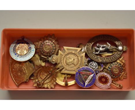 A collection of brass and enamel badges and similar,&nbsp;to include a shield shaped example commemorating Admiral Dewey's Ma