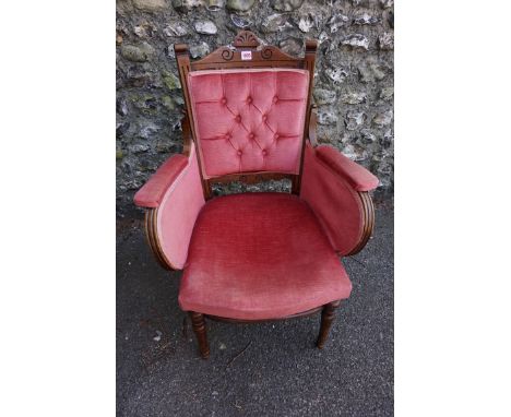 An antique button back elbow chair having pink upholstery.&nbsp; 