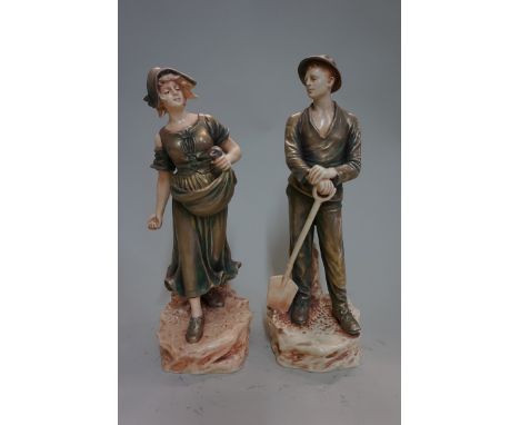 A pair of continental pottery shot enamel figures,&nbsp;24cm high.&nbsp; 
