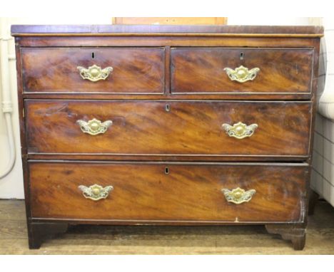 A 19th century mahogany chest of two short and two long graduated drawers with shaped top, profusely carved brass drop handle