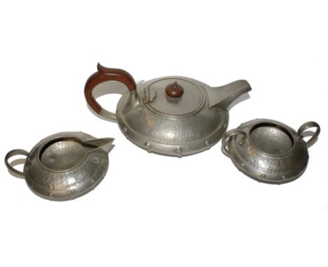 An early 20th century pewter three piece tea service, comprising tea pot, sugar bowl and jug