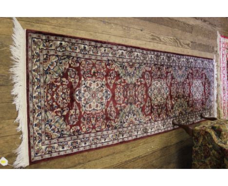 A red ground wool multicolured floor runner, 250cm x 75cm 