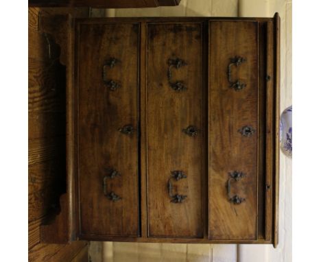 A George III mahogany bachelor's chest with shaped top, brushing slide under, three graduated drawers with carved brass drop 