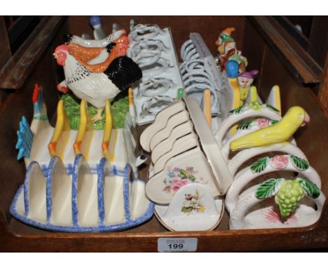 An assortment of ceramic toast racks depicting various characters, including Smurfs, farm animals, etc 