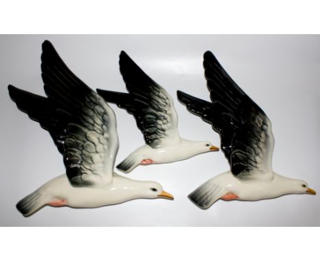 A set of three Beswick ceramic multicoloured birds of graduated sizes