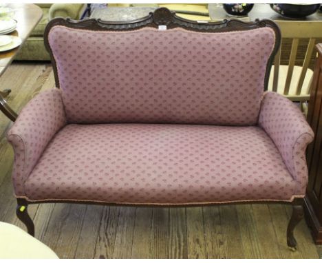 A late Victorian mahogany two-seater drawing room sofa with shell and 'C' scroll carved decoration to the top rail, fabric up