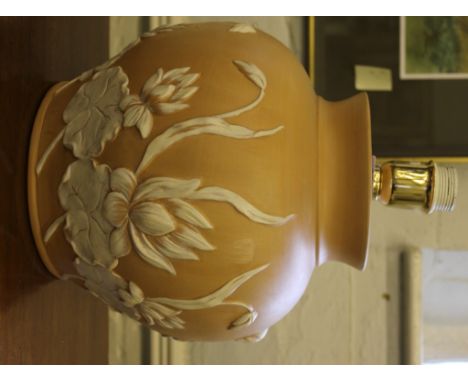 A large peach coloured earthenware baluster shaped lamp stand with white flowers