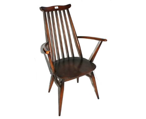 A vintage Ercol kitchen chair with shaped top rail, spindle supports, arched arm rest, dished seat, raised on turned legs 