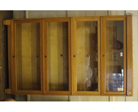 A 1920s Globe Wernicke Limited light oak bookcase with four up and over glazed doors, with circular lacquered metal handles, 